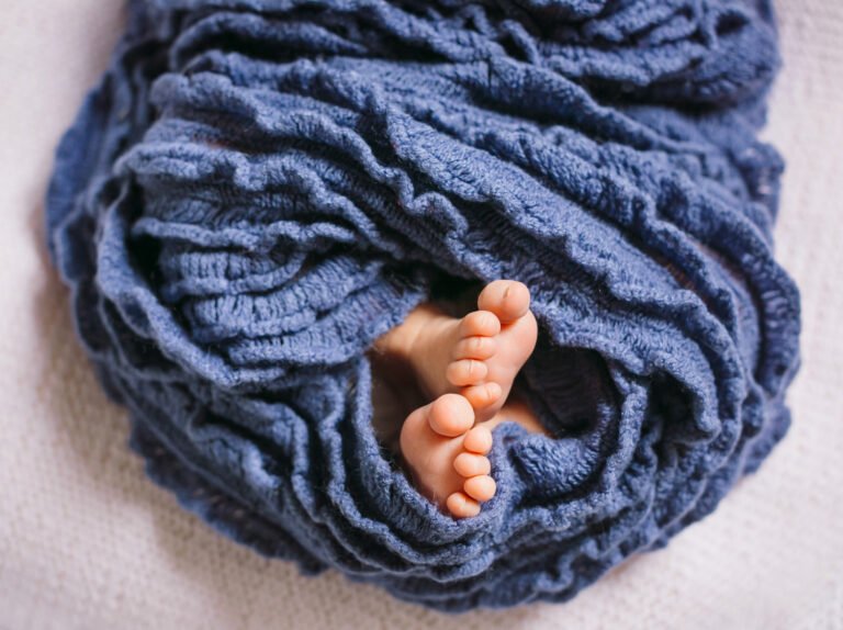 feet-newborn-baby-enveloped-blue-scarf